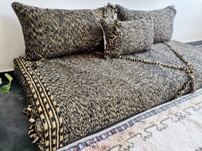 Left view of handwoven Moroccan floor couch in black and mustard – perfect for edgy, warm-toned home styling