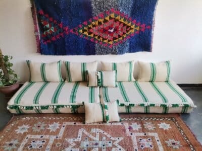 Moroccan wool floor sofa in cream with green stripes and pom-pom trim – handmade low seating for playful boho interiors