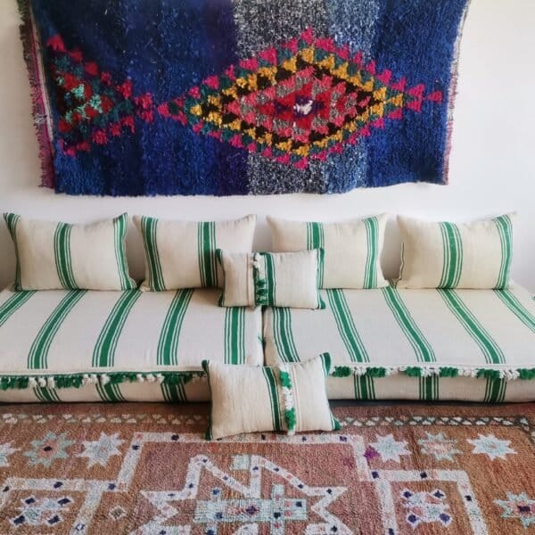 Moroccan wool floor sofa in cream with green stripes and pom-pom trim – handmade low seating for playful boho interiors
