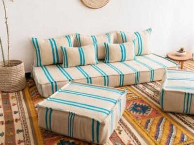Left side image of Moroccan floor seating with turquoise striped pattern on cream – handmade wool low sofa