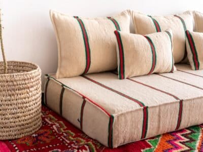 Top image of Moroccan wool floor seating in cream with red and green – ideal for colorful, warm interiors