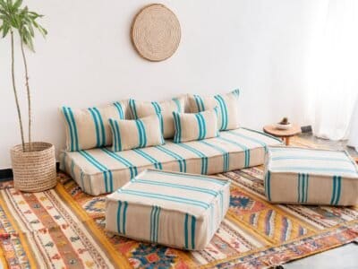 Left side image of Moroccan floor seating with turquoise striped pattern on cream – handmade wool low sofa