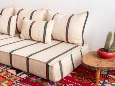 Right view of Moroccan floor sofa in cream with red and green – handmade wool couch for cozy living spaces