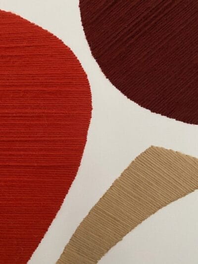 handmade Moroccan wool wall art showing textured wool fibers and natural cotton canvas in terracotta and beige tones.