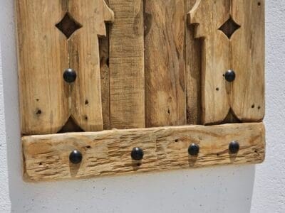 Close-up of bottom detail of Moroccan wooden panel showing natural wood grain and studs