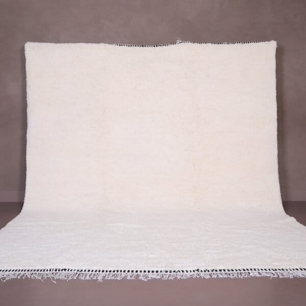 Authentic handmade Moroccan white Beni Ourain rug crafted from 100% natural wool by skilled Berber women artisans. This minimalist solid white wool carpet features a soft texture and timeless elegance, perfect for modern, Scandinavian, or bohemian home interiors. Ideal for living rooms, bedrooms, or wall decor.