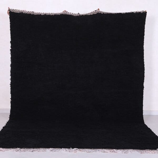 Authentic handmade Moroccan black Beni Ourain rug crafted from 100% natural wool by skilled Berber women artisans. This luxurious black wool rug brings bold elegance, warmth, and cultural charm to modern, bohemian, or minimalist interiors. Perfect for living rooms, bedrooms, or as an eye-catching wall tapestry.