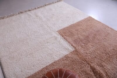 contemporary Moroccan wool rug in tan and ivory tones, highlighting its clean pattern and thick weave.