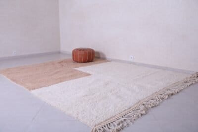 Moroccan ivory and tan rug showing minimalist pattern and soft wool texture, handwoven in the Atlas Mountains.