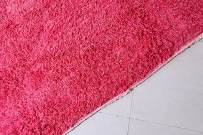 Fringe detail of Moroccan rose pink wool rug with artisanal finish.