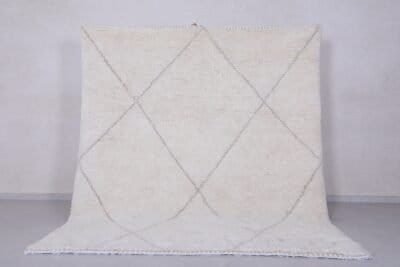 Handmade Moroccan rug with crisp white base and delicate tan trellis pattern, woven from 100% natural lamb wool by skilled Berber artisans in Morocco.