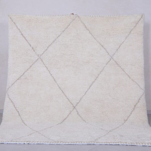 Handmade Moroccan rug with crisp white base and delicate tan trellis pattern, woven from 100% natural lamb wool by skilled Berber artisans in Morocco.