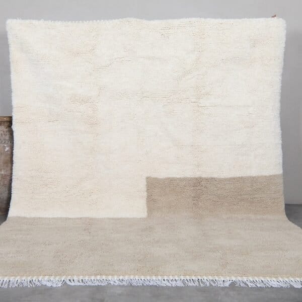 Contemporary Moroccan rug in elegant ivory and taupe tones, hand-knotted by Berber artisans using 100% natural lamb wool, perfect for modern and minimalist interiors.
