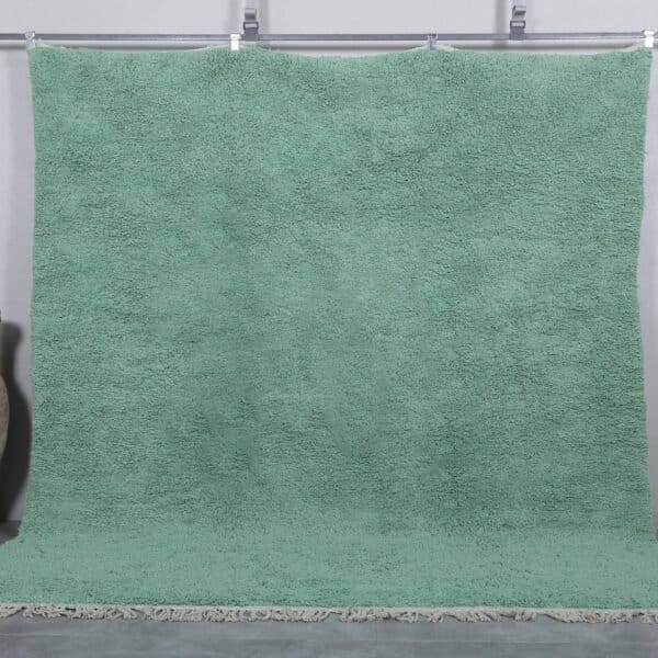 Handmade Moroccan Berber rug in mint green, crafted from 100% natural wool with a soft, minimalist design. This custom Beni Ourain rug blends traditional craftsmanship with a fresh modern color, perfect for boho interiors, cozy bedrooms, or calm living spaces.
