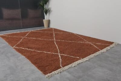 terracotta Moroccan wool rug featuring an ivory trellis design, showcasing the dense, plush wool texture and artisan hand-knotting.