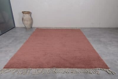 handmade Moroccan rust brown Beni Ourain rug, highlighting the deep earthy tones and dense wool pile woven by skilled Berber artisans in the Atlas Mountains.