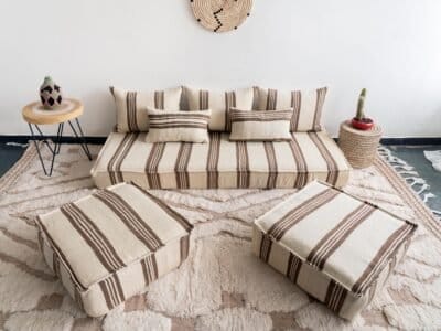 Bohemian living room with Moroccan floor sofa set in cream and brown, styled with rugs and plants