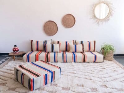 Handmade Moroccan floor couch set in cream wool with blue, orange, and black stripes, includes unstuffed cushions and pillows with zippered covers